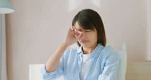 Woman rubbing her dry eyes and wondering if she should seek treatment